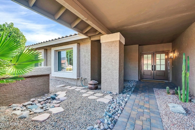 property entrance with stucco siding and french doors