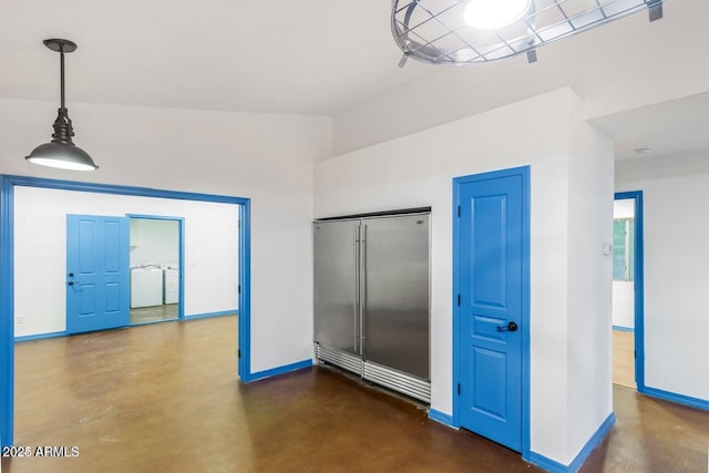 22914 W Sunland Ave, Buckeye, AZ 85326 - empty room featuring concrete flooring, washing machine and dryer, and baseboards