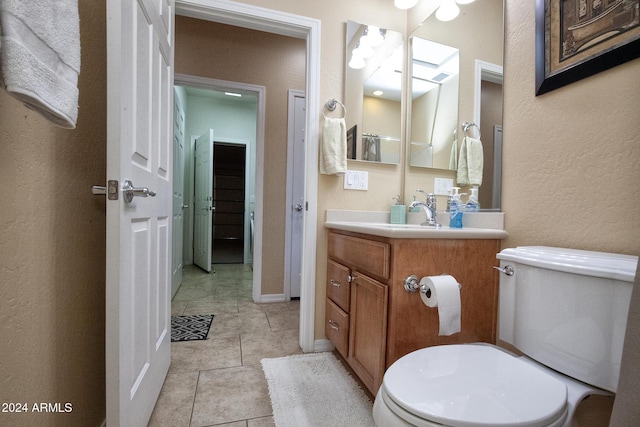 bathroom with tile patterned flooring, vanity, and toilet