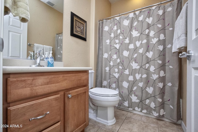 bathroom with tile patterned flooring, vanity, and toilet