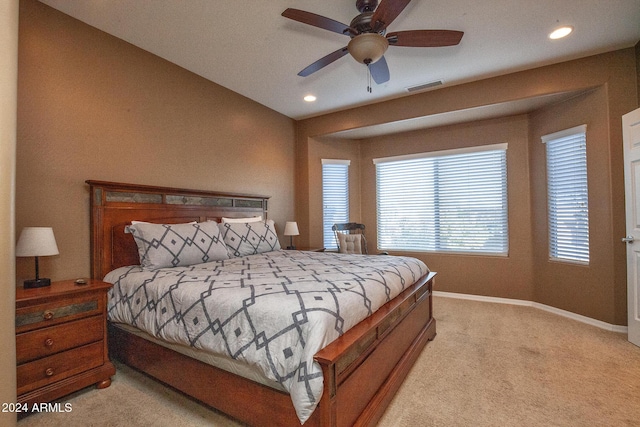 bedroom with ceiling fan, light carpet, and multiple windows