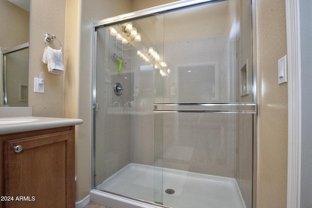 bathroom with vanity and a shower with shower door