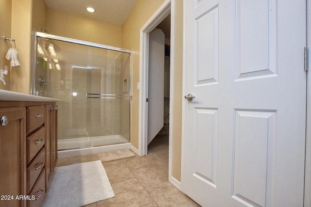 bathroom featuring tile patterned flooring, vanity, and walk in shower