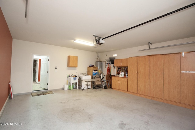 garage featuring washer / dryer, gas water heater, and a garage door opener