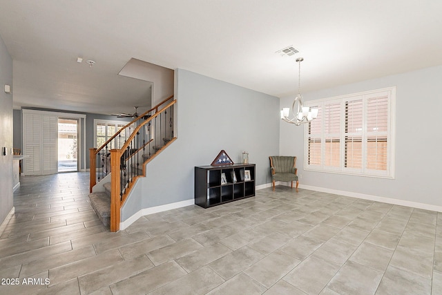 interior space featuring ceiling fan with notable chandelier