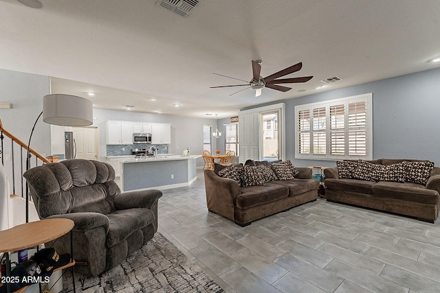 living room with ceiling fan and sink