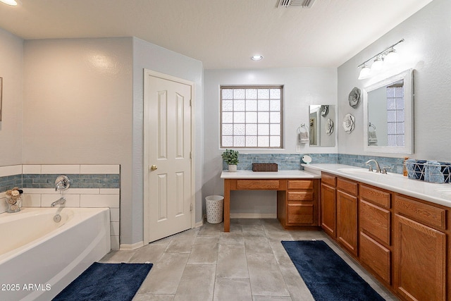 bathroom featuring tile patterned flooring, vanity, and a bathing tub