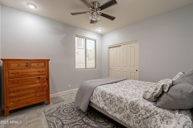 bedroom with light tile patterned flooring, ceiling fan, and a closet