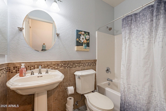 bathroom with tile walls, toilet, and shower / bath combination with curtain