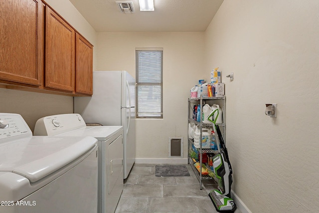 clothes washing area with washing machine and clothes dryer and cabinets