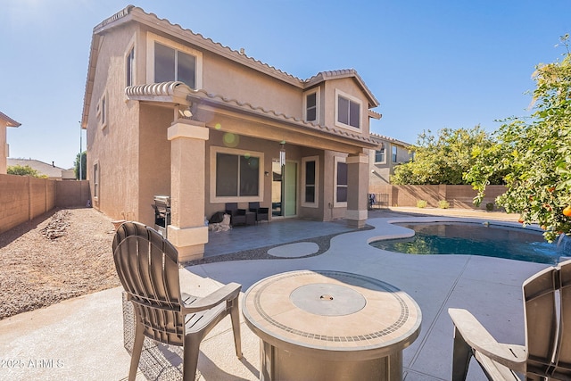 rear view of house featuring a patio area and a fenced in pool