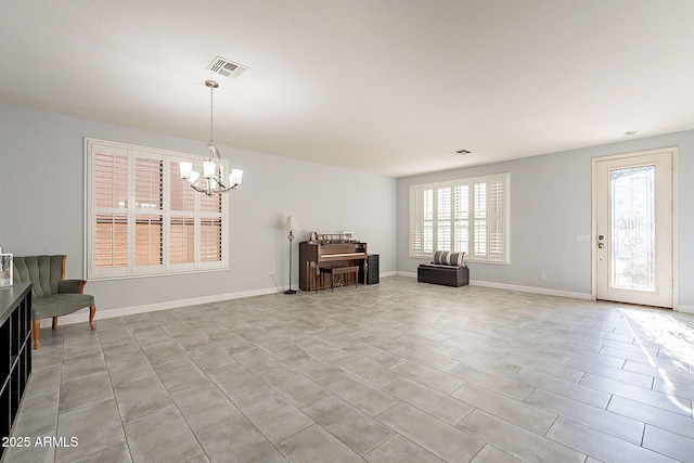 sitting room with light tile patterned flooring, a chandelier, and a wealth of natural light