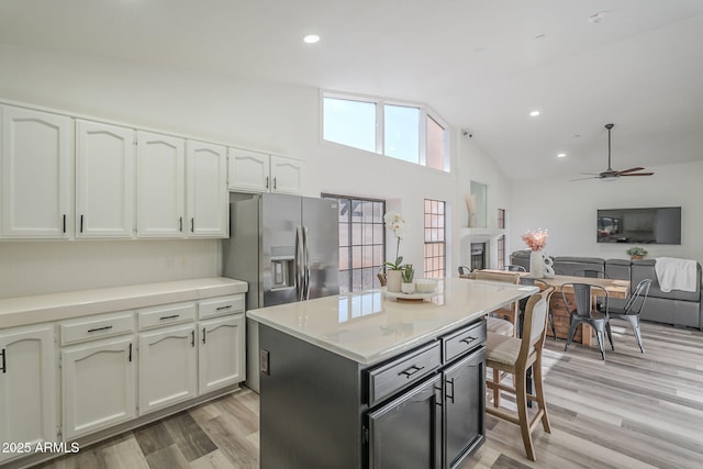 kitchen featuring lofted ceiling, white cabinetry, ceiling fan, and stainless steel refrigerator with ice dispenser