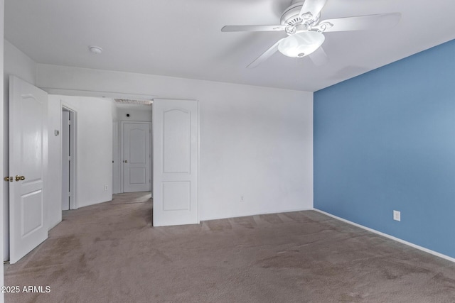 carpeted spare room featuring ceiling fan