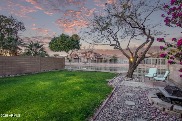 yard at dusk featuring a fire pit