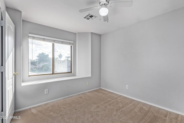 spare room with ceiling fan and light colored carpet