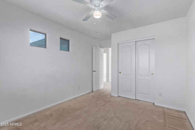 unfurnished bedroom featuring light carpet, ceiling fan, and a closet