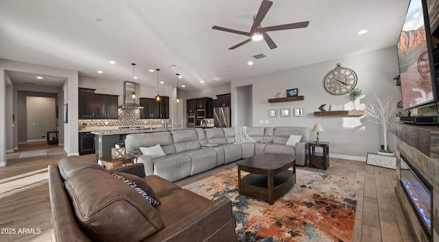 living room with ceiling fan and light hardwood / wood-style floors