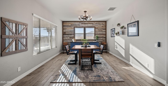 dining space with hardwood / wood-style flooring and a notable chandelier