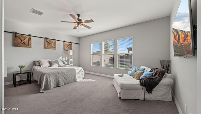 bedroom featuring a barn door, carpet floors, and ceiling fan