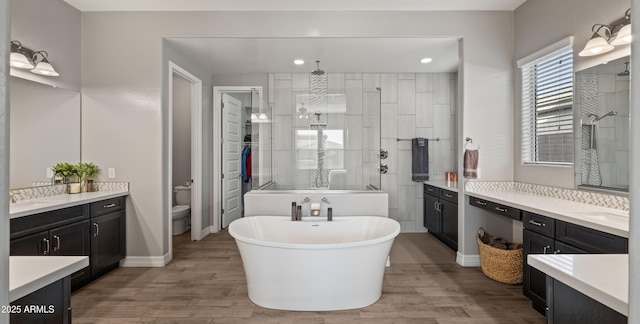 full bathroom featuring wood-type flooring, separate shower and tub, and vanity