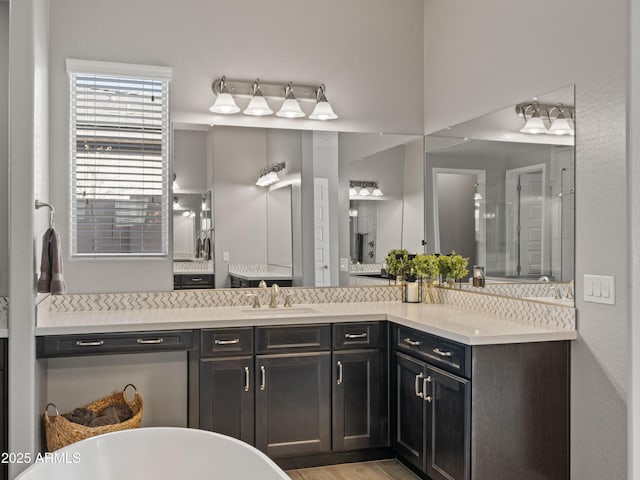 bathroom with vanity, hardwood / wood-style floors, tasteful backsplash, and a tub