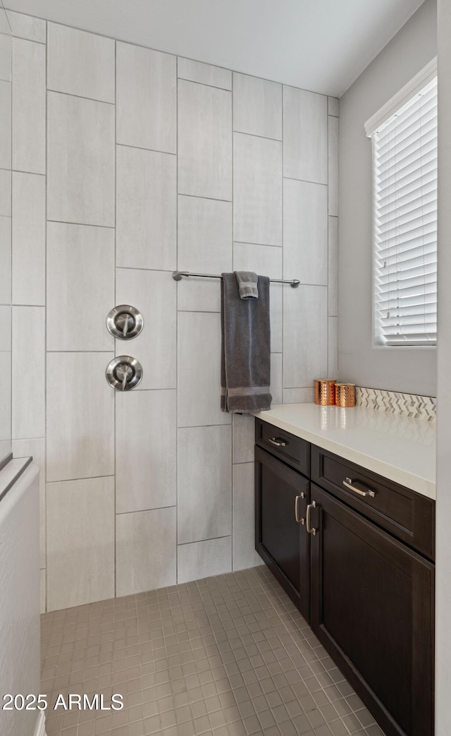 bathroom with tile walls, vanity, and tiled shower