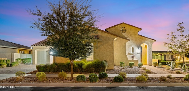 mediterranean / spanish-style house with a garage