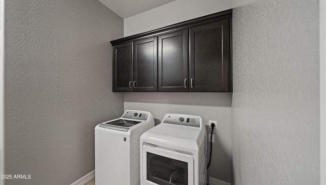 washroom with washing machine and dryer and cabinets