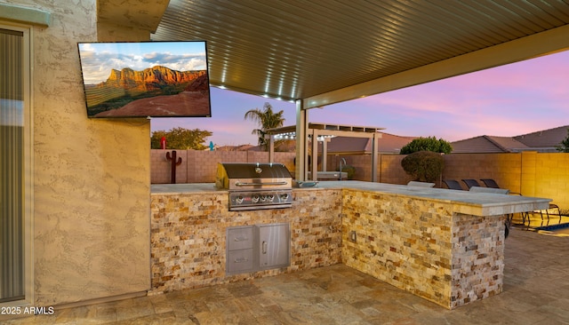 view of patio / terrace with exterior bar, grilling area, and an outdoor kitchen