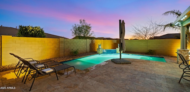 pool at dusk featuring a patio area