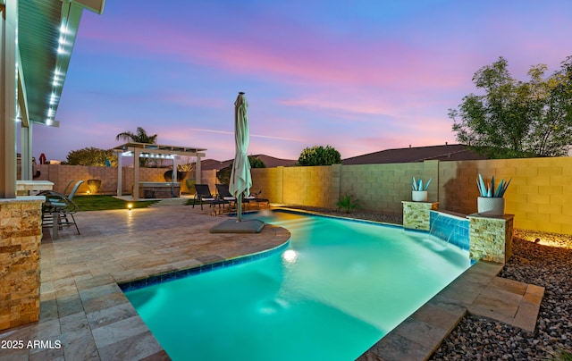 pool at dusk featuring pool water feature, a patio area, and a pergola