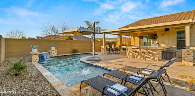 view of pool featuring exterior bar, pool water feature, and a patio area