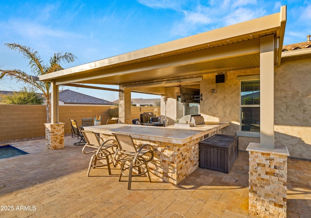 view of patio / terrace featuring area for grilling, an outdoor bar, and exterior kitchen