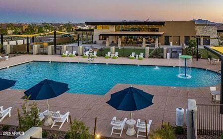 pool at dusk featuring a patio