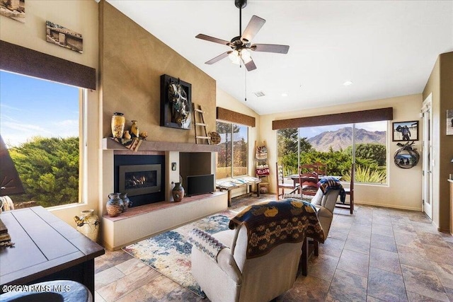 10796 N Saddle Pass Rd, Prescott, AZ 86305 - living area with a warm lit fireplace, ceiling fan, lofted ceiling, stone tile flooring, and recessed lighting