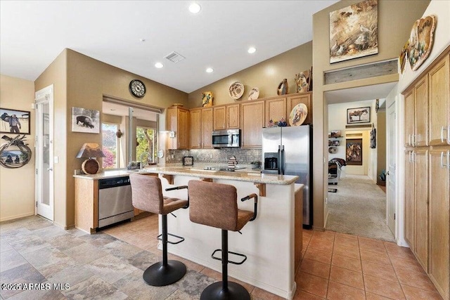 10796 N Saddle Pass Rd, Prescott, AZ 86305 - kitchen with appliances with stainless steel finishes, a breakfast bar, decorative backsplash, recessed lighting, and light carpet