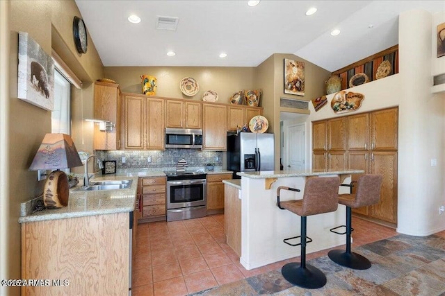 10796 N Saddle Pass Rd, Prescott, AZ 86305 - kitchen with appliances with stainless steel finishes, backsplash, a breakfast bar, lofted ceiling, and light tile patterned floors