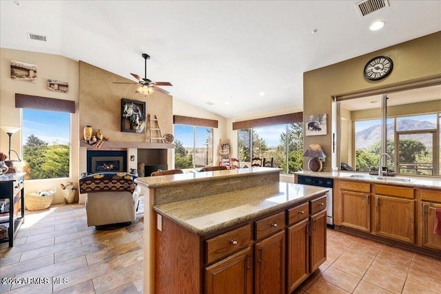 10796 N Saddle Pass Rd, Prescott, AZ 86305 - kitchen featuring dishwashing machine, vaulted ceiling, ceiling fan, brown cabinets, and a center island