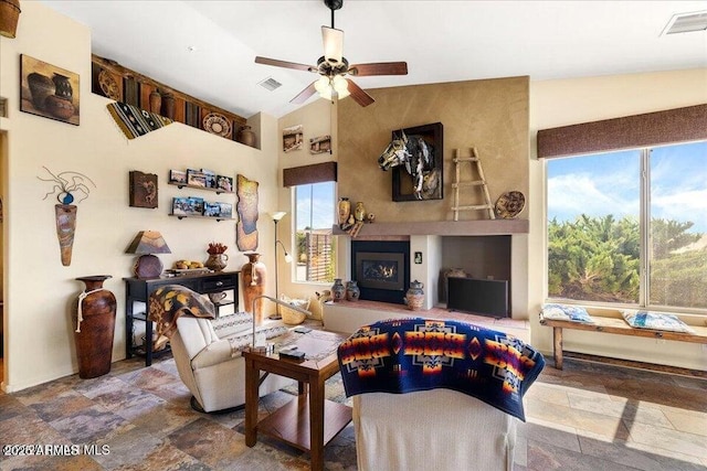 10796 N Saddle Pass Rd, Prescott, AZ 86305 - living area featuring a lit fireplace, a ceiling fan, lofted ceiling, and stone finish floors