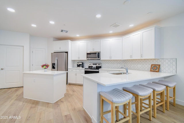 2511 W Queen Creek Rd Unit 374, Chandler, AZ 85248 - kitchen with stainless steel appliances, a sink, light wood-style floors, decorative backsplash, and recessed lighting