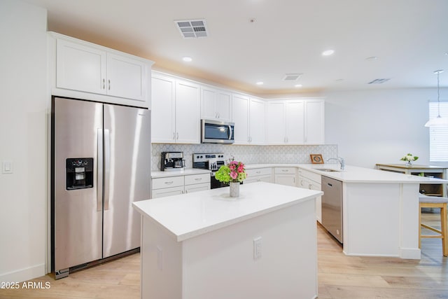 2511 W Queen Creek Rd Unit 374, Chandler, AZ 85248 - kitchen featuring stainless steel appliances, light wood finished floors, a peninsula, white cabinets, and recessed lighting