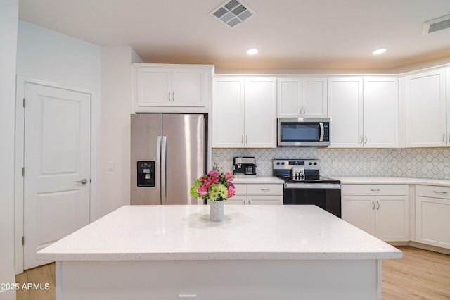 2511 W Queen Creek Rd Unit 374, Chandler, AZ 85248 - kitchen featuring appliances with stainless steel finishes, a kitchen island, white cabinetry, decorative backsplash, and recessed lighting