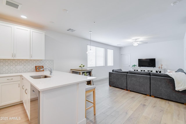2511 W Queen Creek Rd Unit 374, Chandler, AZ 85248 - kitchen with a sink, stainless steel dishwasher, light wood-style floors, open floor plan, and tasteful backsplash
