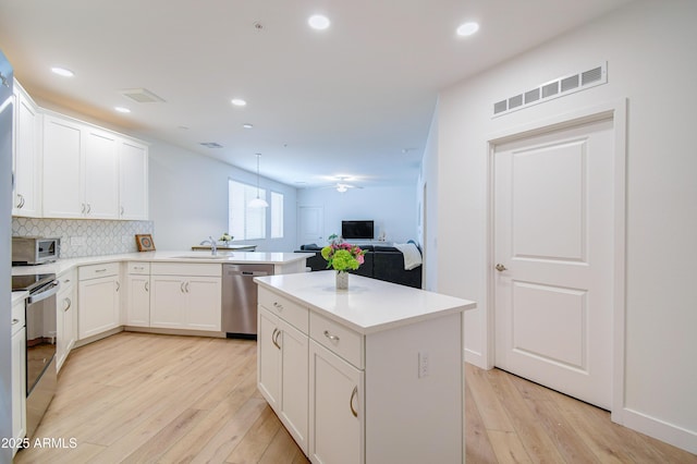 2511 W Queen Creek Rd Unit 374, Chandler, AZ 85248 - kitchen featuring appliances with stainless steel finishes, light wood-style flooring, a peninsula, decorative backsplash, and recessed lighting
