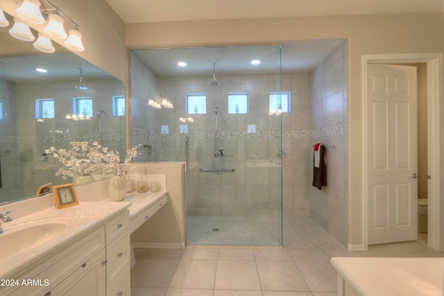 bathroom with tile patterned flooring, vanity, and tiled shower