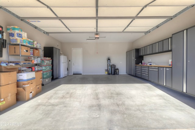 garage with a garage door opener and white fridge