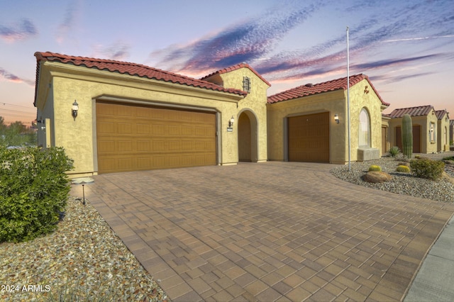 27552 W Tonopah Dr, Buckeye, AZ 85396 - mediterranean / spanish home with a garage, stucco siding, decorative driveway, and a tiled roof