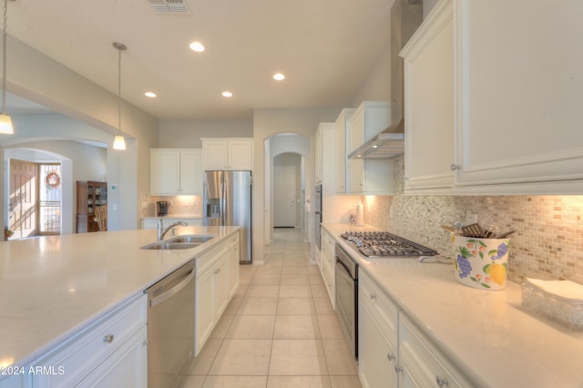27552 W Tonopah Dr, Buckeye, AZ 85396 - kitchen featuring arched walkways, appliances with stainless steel finishes, a sink, wall chimney exhaust hood, and white cabinets