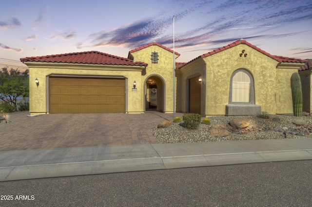 27552 W Tonopah Dr, Buckeye, AZ 85396 - mediterranean / spanish-style house with an attached garage, stucco siding, decorative driveway, and a tile roof